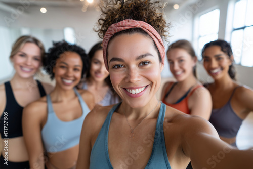 Group of young women taking selfie during fitness class, sports outfits, studio background with natural light, 