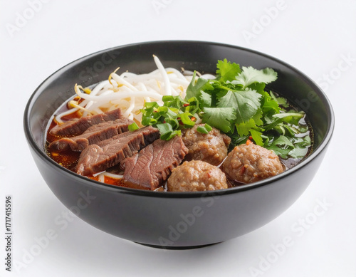 A black bowl of traditional Thai boat noodle soup, featuring a rich dark broth, sliced beef, meatballs, fresh bean sprouts, and cilantro.