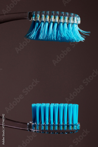 A comparison is made between a new and an old toothbrush. The old toothbrush bristles are frayed, illustrating the need for routine replacement for optimal oral health.