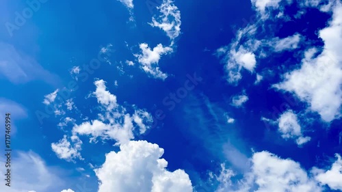 Cloud formations in bright blue sky representing time-lapse clouds  