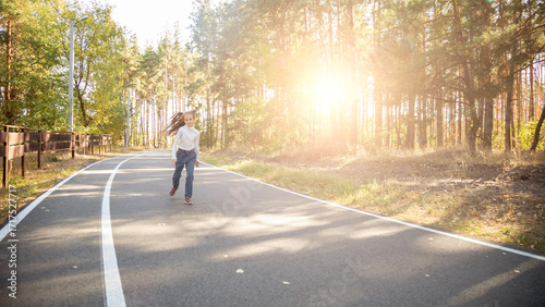 Wallpaper Mural Happy child girl having fun walking a park on a sunset Torontodigital.ca