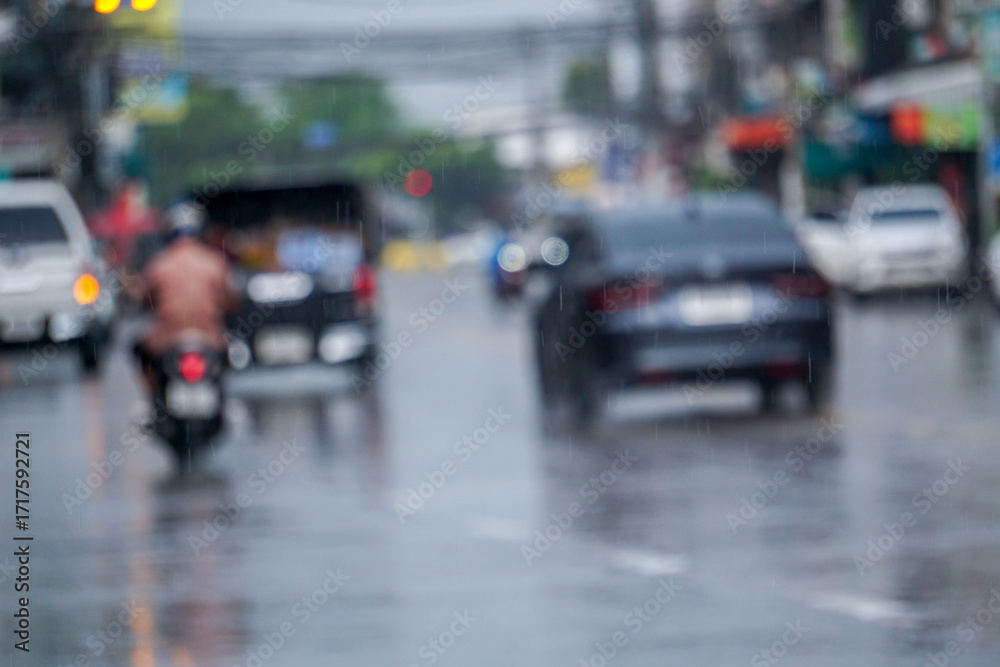 Fototapeta premium On a rainy city street, rain drops on city street, sidewalk and cars driving in the rain, close up, water splash, wallpaper concept and other blurred backgrounds for text.