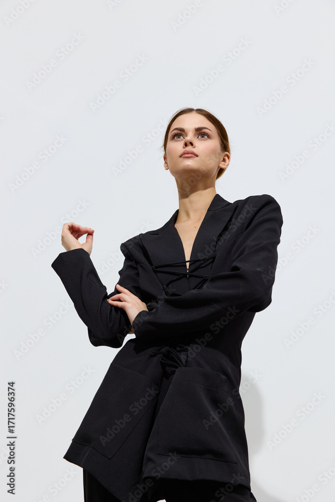 Ταπετσαρία Fashion woman wearing black modern jacket poses against a plain light background with a confident and stylish expression, showcasing contemporary beauty and grace