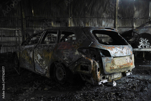 a burnt-out car at a service station