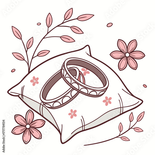 Two elegant wedding rings resting on a soft pillow adorned with delicate pink flowers and branches