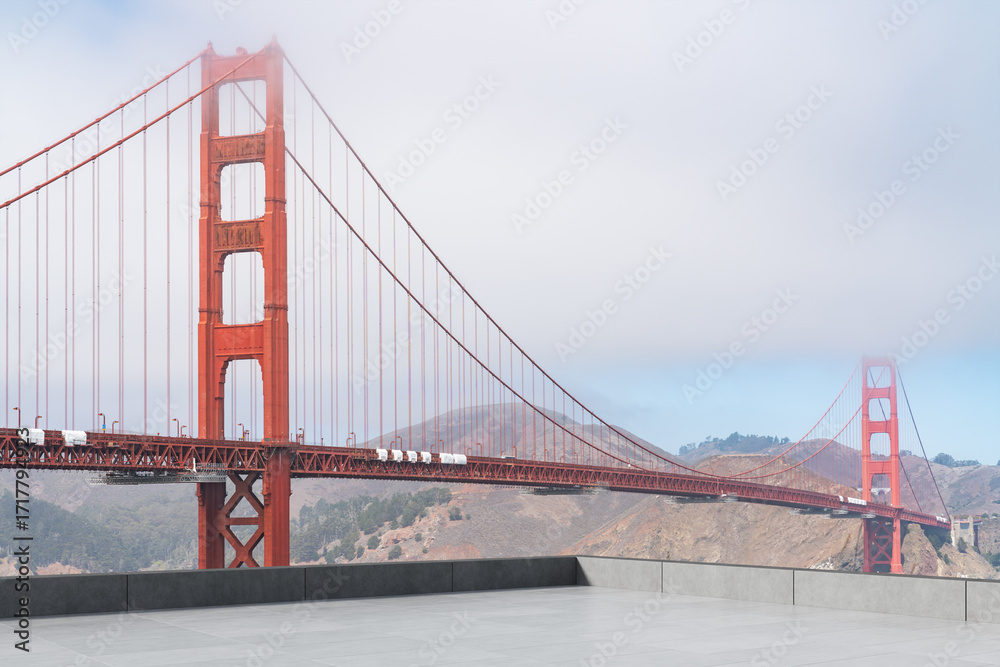 Obraz premium Golden Gate Bridge in San Francisco partially covered by fog with empty terrace.