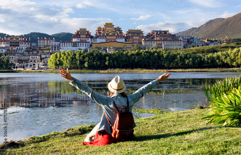 Φωτογραφία Young Asian woman sitting in front of Songzanlin Monastery in China, a famous tourist attraction in Asia for summer travel