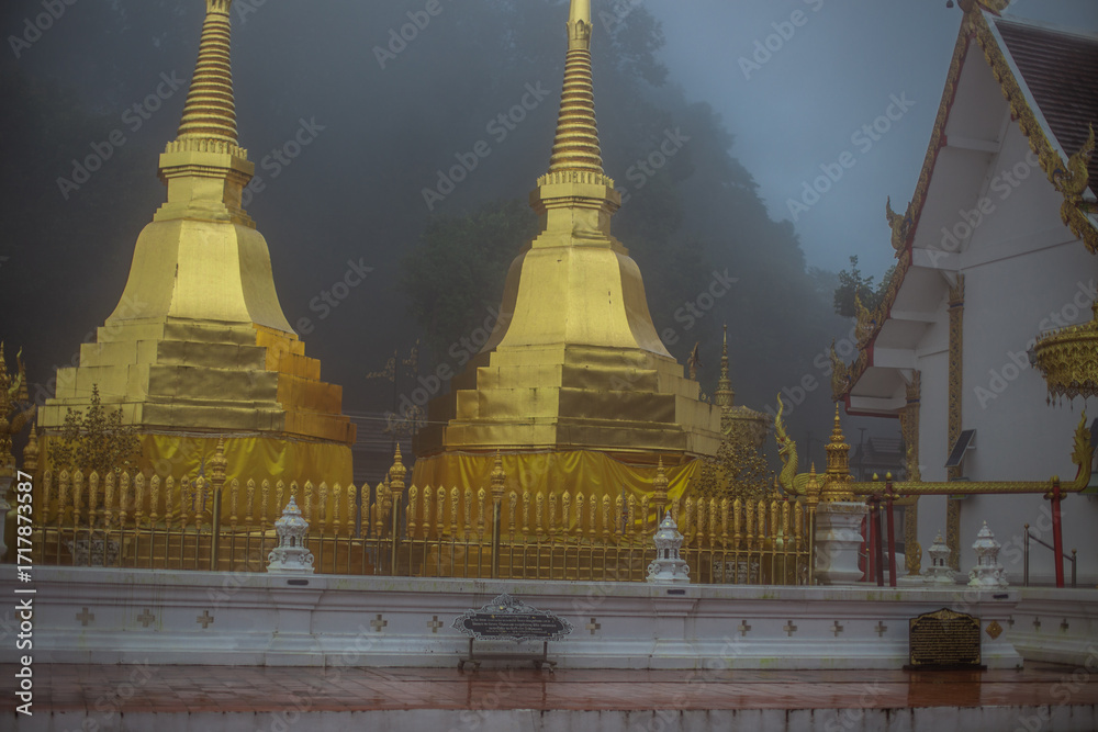 Fototapeta premium The background of the religious tourist attraction Wat Phra That Doi Tung in the mist in Chiang Rai Province, Thailand, where travelers often stop to make merit.