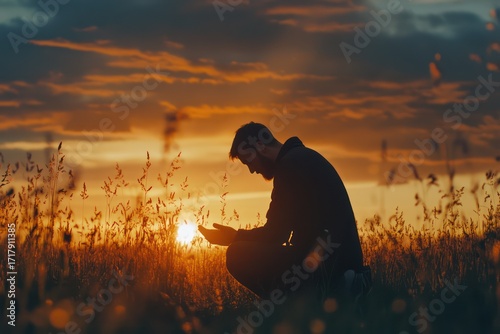 Man praying on knees at sunset worship