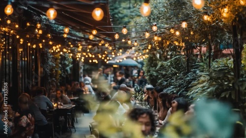 Evening outdoor dining scene, soft lights glow over tables of people