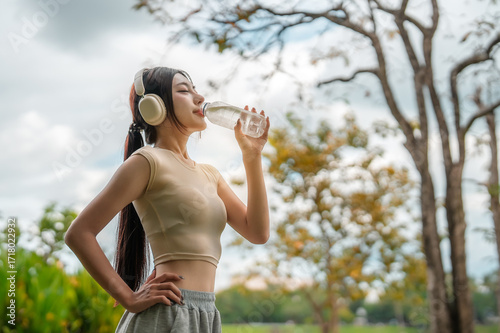 Wallpaper Mural Asian woman exercise in garden and drinking water from bottle. Torontodigital.ca