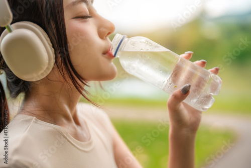 Wallpaper Mural Asian woman exercise in garden and drinking water from bottle. Torontodigital.ca