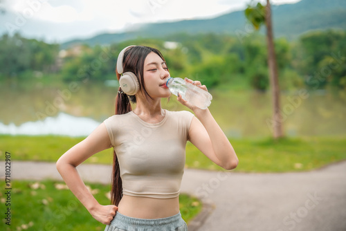 Wallpaper Mural Asian woman exercise in garden and drinking water from bottle. Torontodigital.ca
