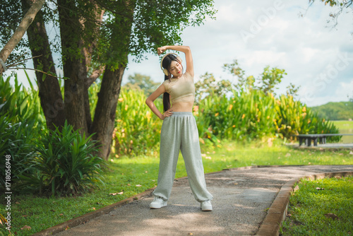 Wallpaper Mural A sporty woman in sportswear exercises at the garden Torontodigital.ca