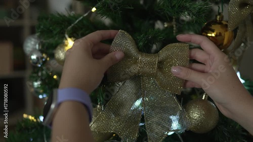Woman's hands decorating a christmas tree