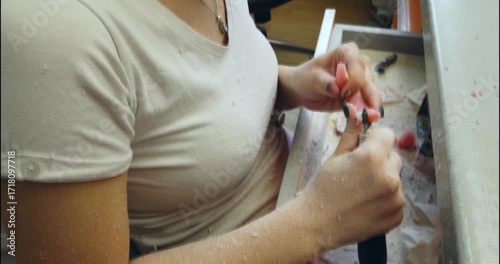 Prosthetics hands while working on the denture, false teeth, a study and a table with dental tools