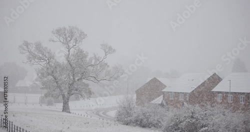 Snow falling on a cold winter day in England in a typical village
