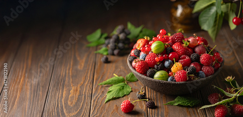 Various fresh berries in a bowl. Mix of different fresh berries on wooden background. Strawberries, raspberries, gooseberries and cherries are presented.