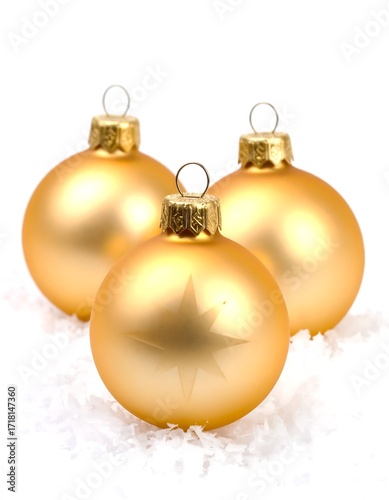 Three gold Christmas ornaments on snow