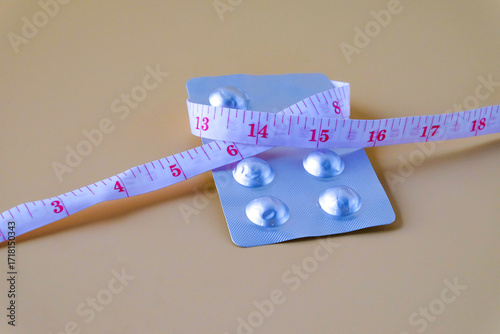 A pills and a measuring tape suggest a journey towards health.