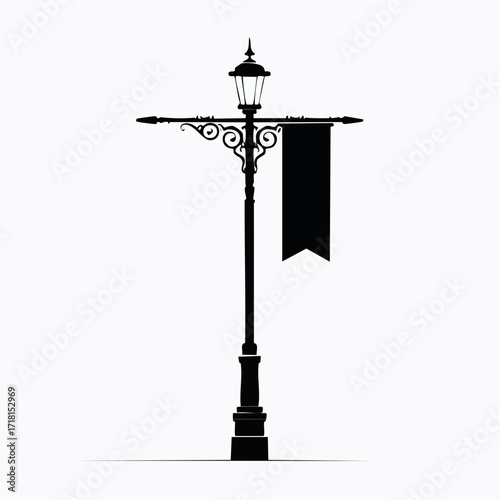 Silhouette of a vintage street lamp with a banner hanging from it.