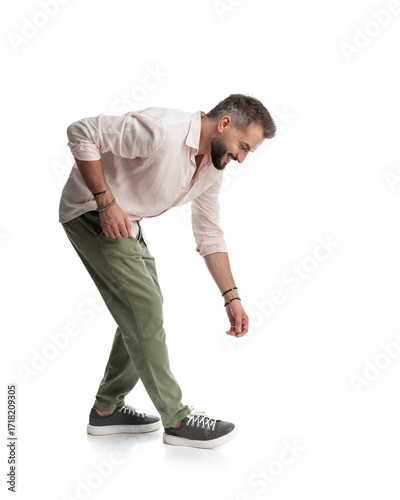 casual fashion man bending over and grabbing something from the floor