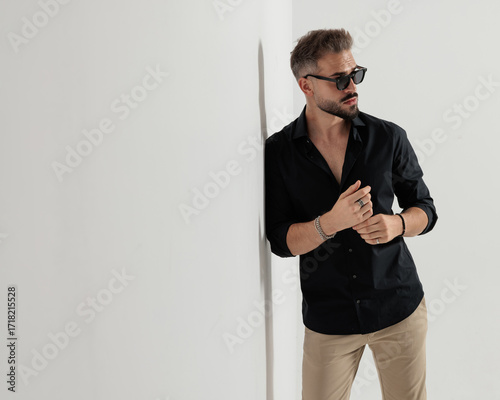 cool fashion guy with sunglasses touching fingers and looking to side