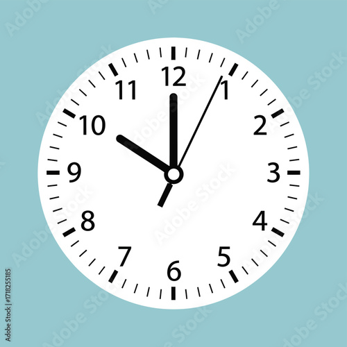 A simple wall clock displaying ten o clock time is passing by