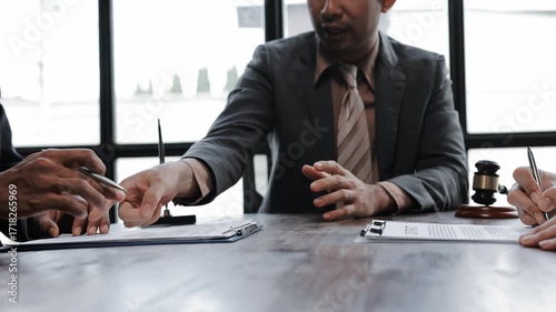 Professional legal team analyzing contract details, reviewing document specifics with focused collaboration during corporate meeting negotiations
