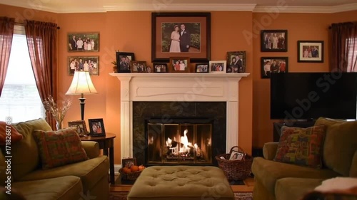 Cozy living room with a fireplace, family photos on the wall, and warm lighting creating comfort
