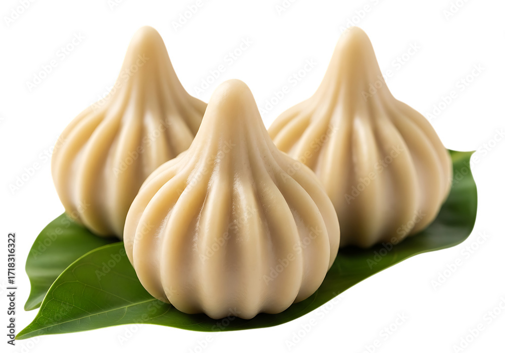 Obraz premium Three sweet indian modak dumplings made of rice flour and jaggery on green leaves isolated on transparent background