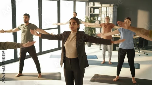 Group of people in office doing yoga, wellness, health, and stretching exercise for balance and focus.