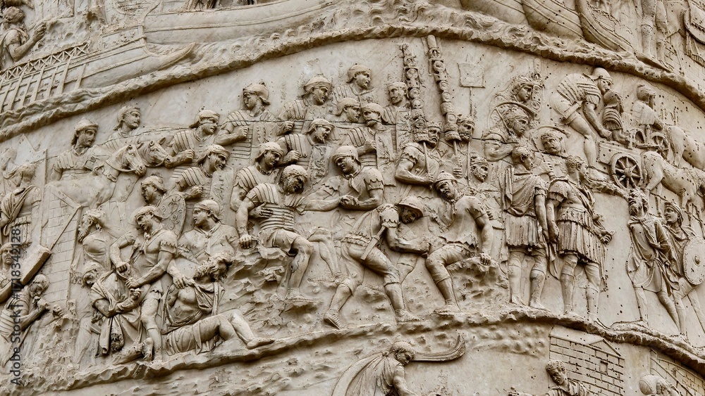 Obraz premium Rome, Italy - 11 January 2025. Trajan’s Column depicts injured soldiers being aided and the Roman army advancing with standards and wagons during the Dacian campaign.