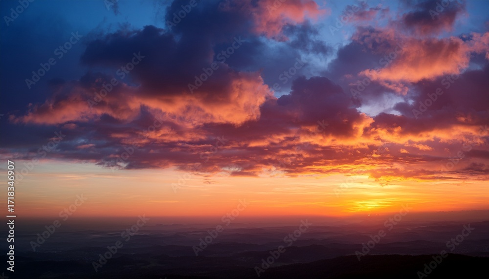 Fototapeta premium Vibrant Sunset Glow Illuminating Soft Clouds In The Horizon During Twilight Hours
