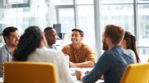 Diverse group of young professionals having a business meeting in modern conference room with sunlight.