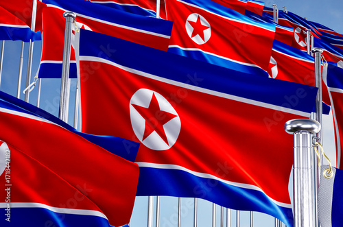 north korea many flags in row waving together on blue cloudy sky,