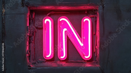 A luminous neon sign glows brilliantly, illuminating the word 'IN' on a dark, reflective surface, symbolizing entry, arrival, or the beginning of a new phase. Stock Image.