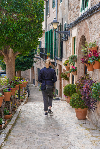 Woman walking through plant filled stairway of Valldemossa Spain