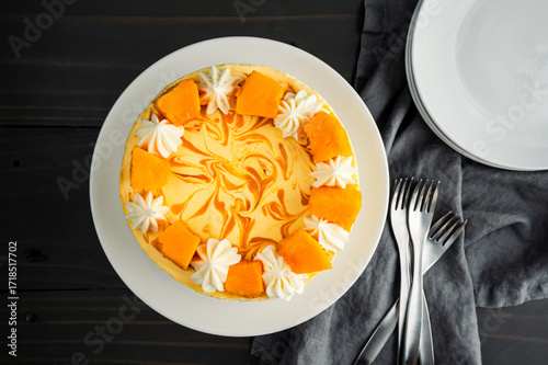Mango Mousse Cake Overhead View: Directly above a mousse cake with mango swirl, cream cheese frosting, and fresh mango decorations