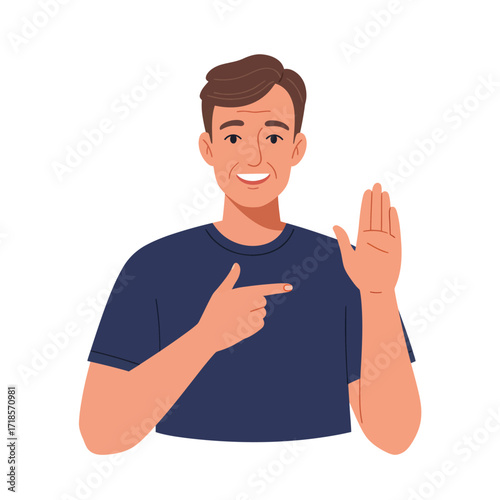 A smiling man in a dark blue t-shirt gestures with his left hand raised and his right index finger pointing to the left.