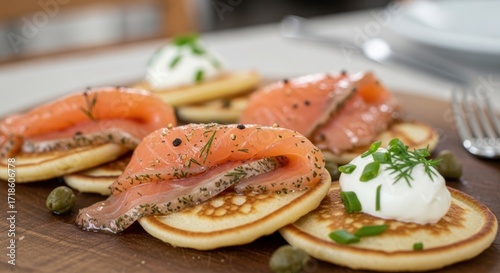 Gourmet blinis with smoked salmon sour cream dill and capers appetizer.