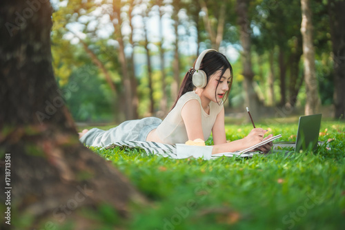 Wallpaper Mural A young woman enjoys spending time writing and reading in the park. Torontodigital.ca