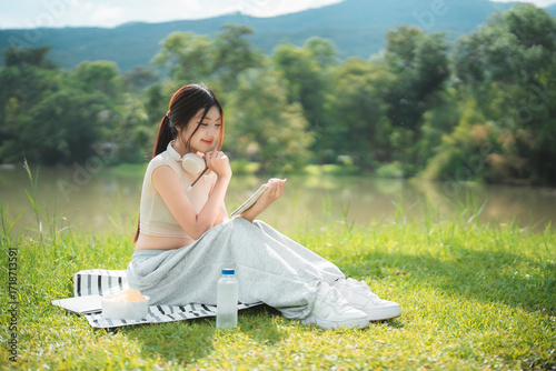Wallpaper Mural A young woman enjoys spending time writing and reading in the park. Torontodigital.ca
