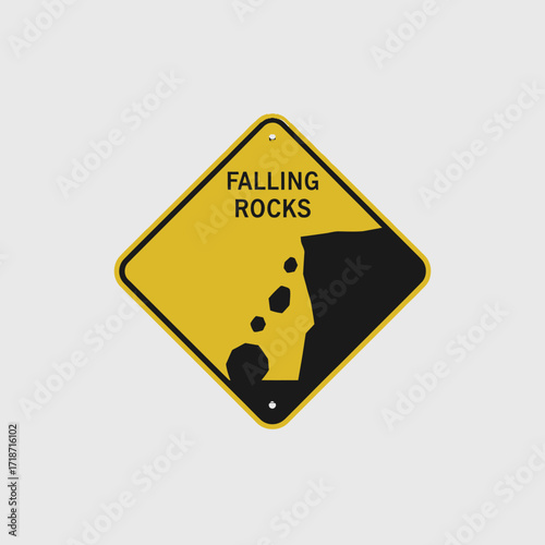 Yellow diamond-shaped sign warning of falling rocks.