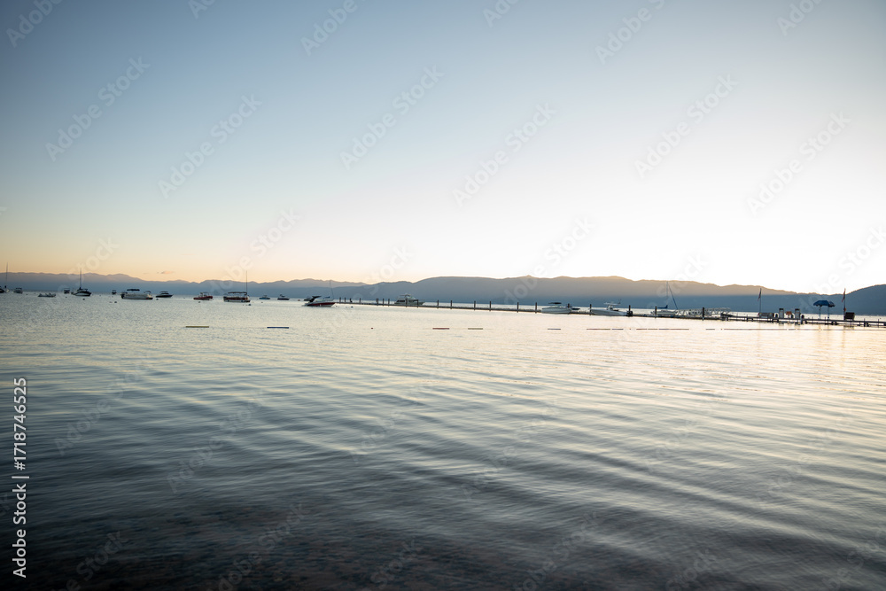Obraz premium Sunrise over South Lake Tahoe, calm waters andboats