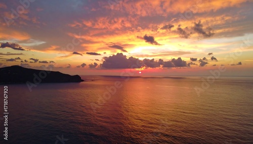 Fototapeta Naklejka Na Ścianę i Meble -  Fiery sunset over tranquil ocean and distant land