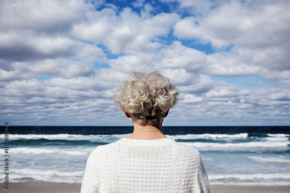 Fototapeta premium Elderly woman enjoying herself at the beach with a view from behind. Back