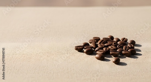 Aromatic dark roasted coffee beans creating a small pile on a light textured fabric surface, bathed in soft morning light with extensive copy space.