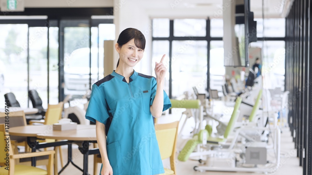 Obraz premium 介護施設で指差しをするアジア人介護福祉士