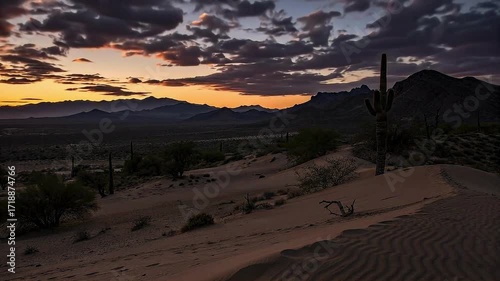 A dramatic time-lapse of a desert landscape with saguaro cacti, transitioning from a fiery sunset to a starry night.